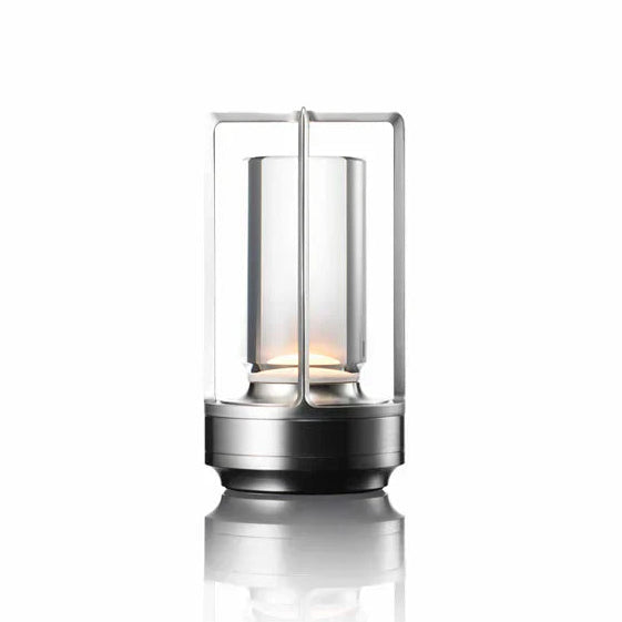 Candle lantern with metallic base and glass container on a white background