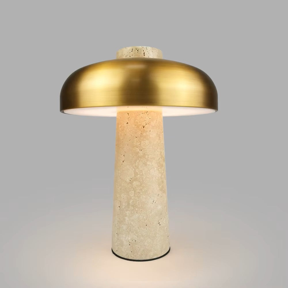Table lamp with gold metallic shade and beige stone base on a gray background