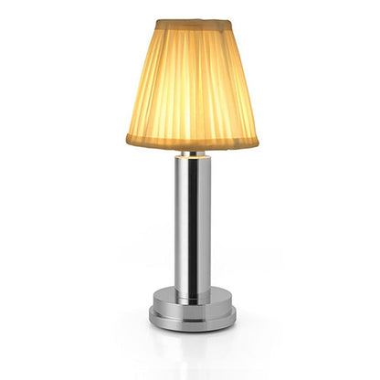Table lamp with a gold shade and silver base on a white background