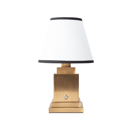 Table lamp with gold base and white shade on a white background