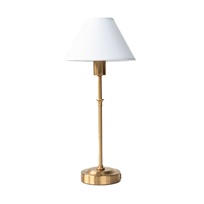 Table lamp with brass base and white shade on a white background