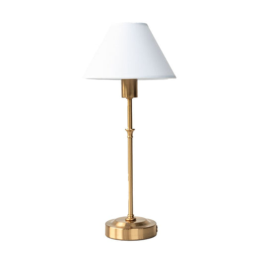 Table lamp with brass base and white shade on a white background