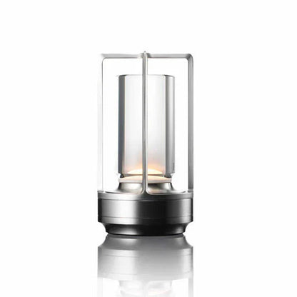 Candle lantern with metallic base and glass container on a white background