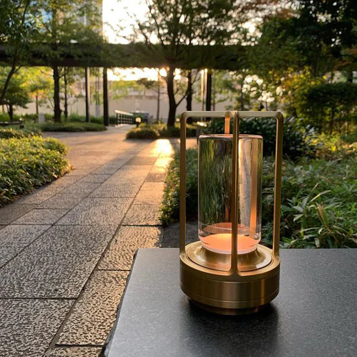 Decorative lantern with a candle on a table outdoors