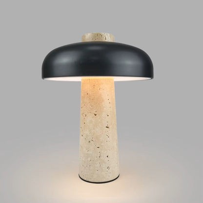 Table lamp with black shade and textured beige base on a gray background