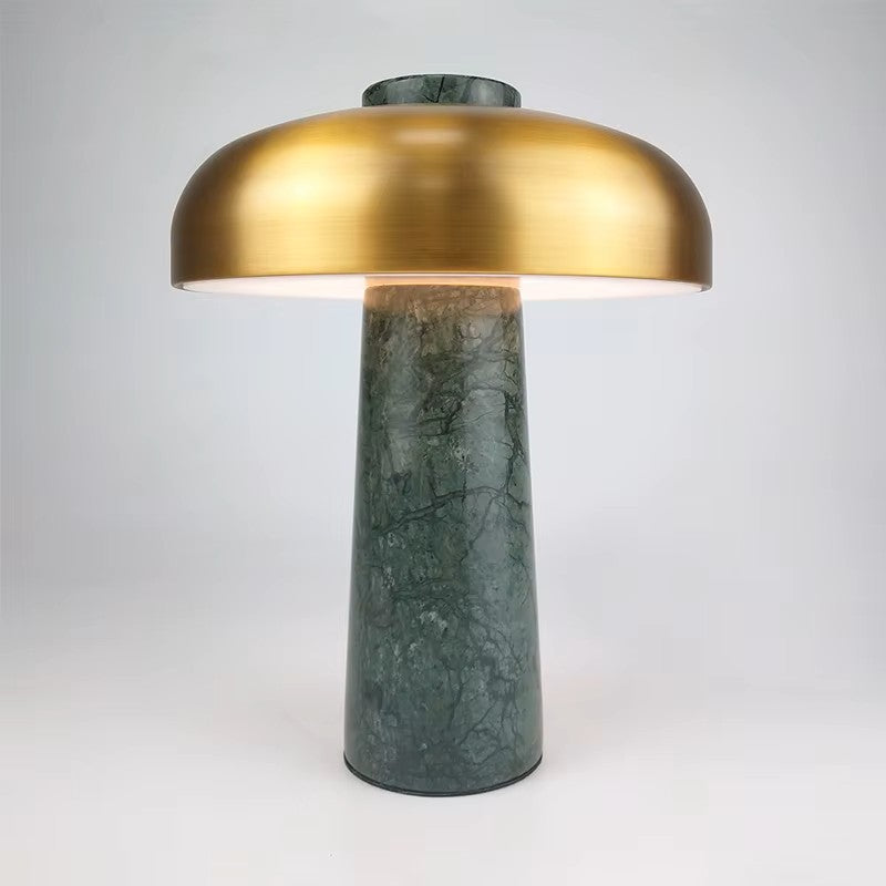Table lamp with gold shade and green marble base on a white background